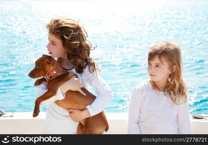 sister kid girls with dog mini pinscher on the sea view from a boat