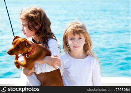 sister kid girls with dog mini pinscher on the sea view from a boat