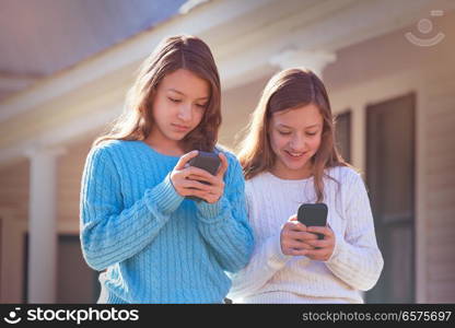 Sister twins having fun with technology mobile smartphone