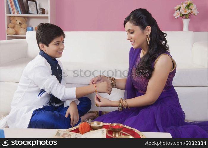 Sister tying rakhi on her brother wrist