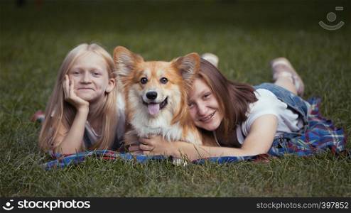 sisters and their dog on a grass at the park