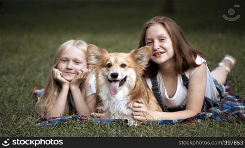 sisters and their dog on a grass at the park