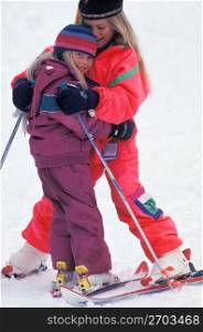 Sisters hugging on ski hill