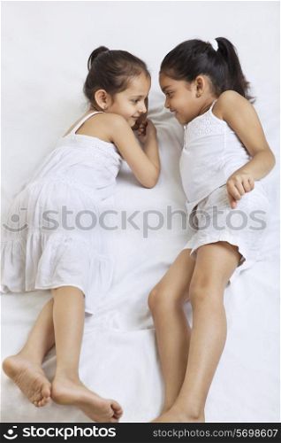 Sisters lying on bed