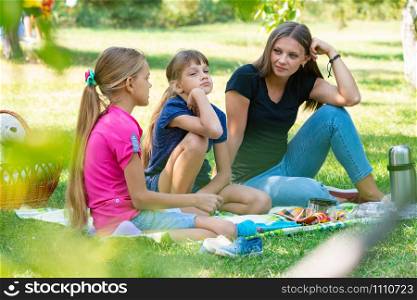 Sisters of different ages talking cute on a picnic