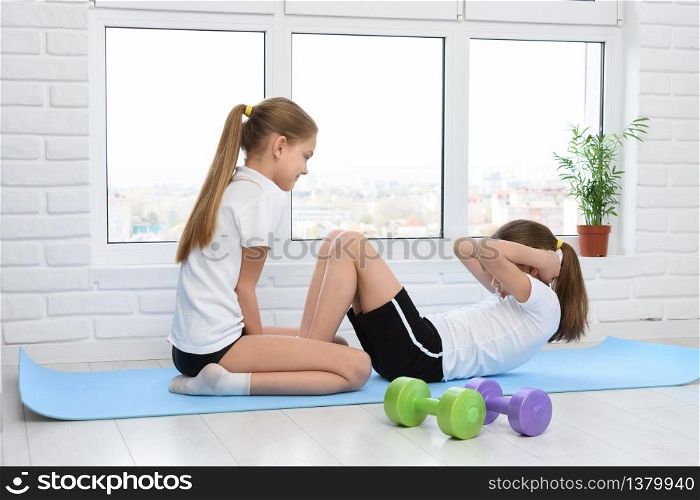 Sisters perform sports exercises at home in self-isolation mode