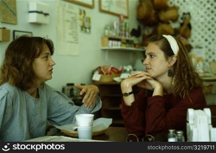 Sisters Talking at Kitchen Table