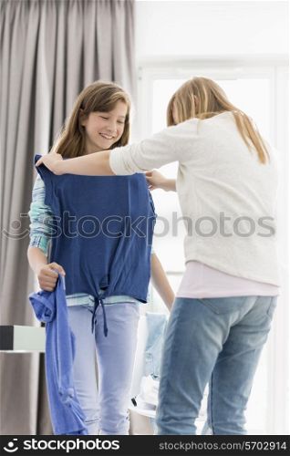 Sisters trying on clothes at home