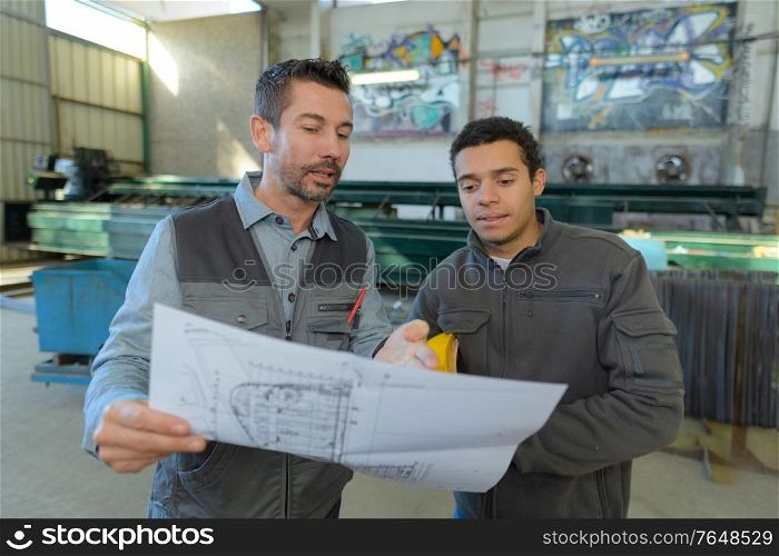 site inspector making inspection report in big industrial hall