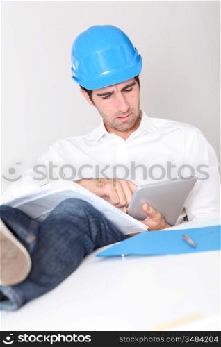 Site manager in office using electronic tablet