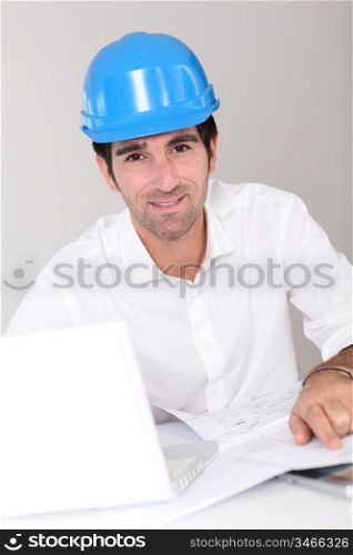 Site manager in office with security helmet