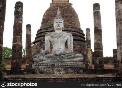 Sitting Buddha and brick columns in old Sukhotai, Thailand