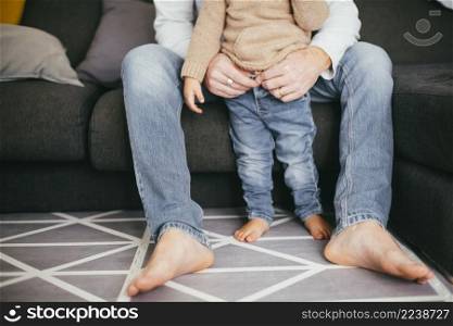 sitting father holding standing toddler