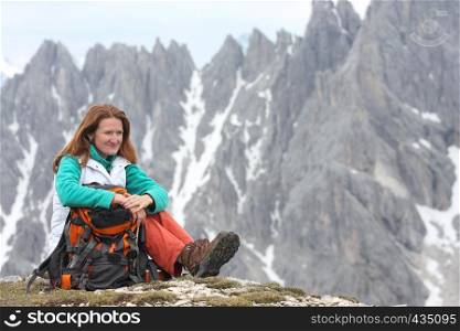 sitting smiling girl with the high rocky mountains at the background
