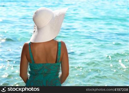 Sitting young woman in the white hat