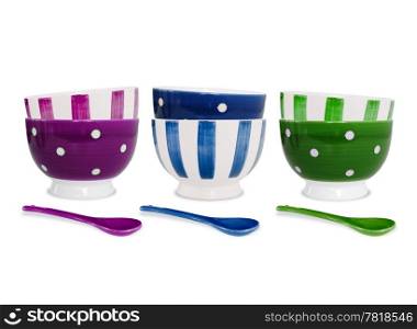 Six bowls in different colors and patterns and three spoons on white background