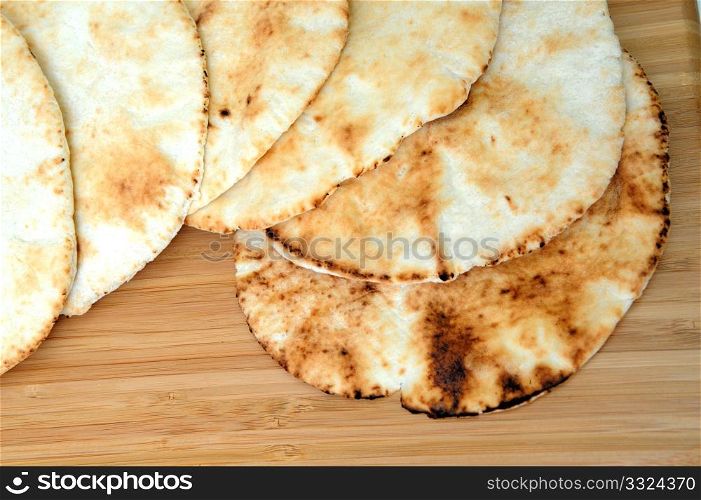 Six middle eastern flat bread disks stacked on top of each other.. Pita Bread