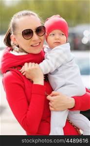 Six months old baby boy with his mother outdoors