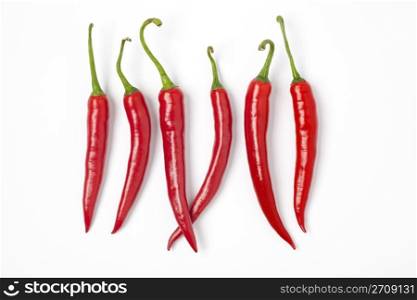 Six Red Hot Chili Peppers In A Row On White Background