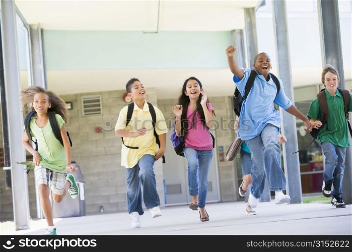 Six students running away from front door of school excited