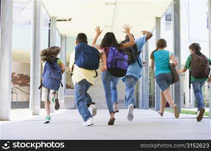 Six students running to front door of school excited