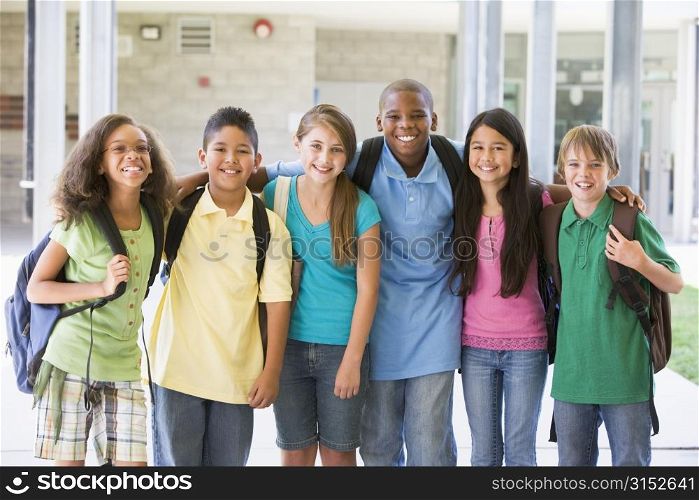 Six students standing outside school together smiling