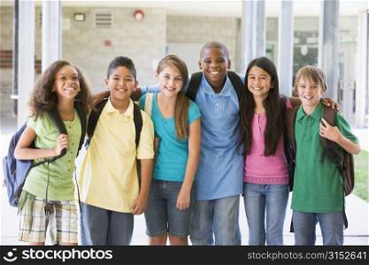 Six students standing outside school together smiling