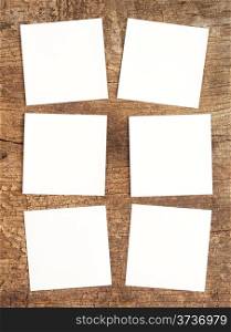 Six white square sheets on a wooden background