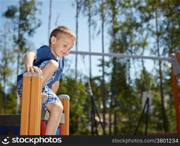 Six year old boy climbing on playground