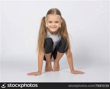 six year old girl aspiring gymnast performs a number of training exercises. An aspiring gymnast performs a warm toes