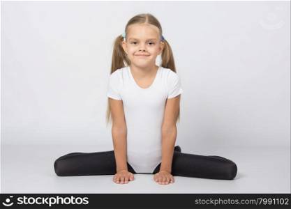 six year old girl aspiring gymnast performs a number of training exercises. Girl gymnast performs exercises Frog