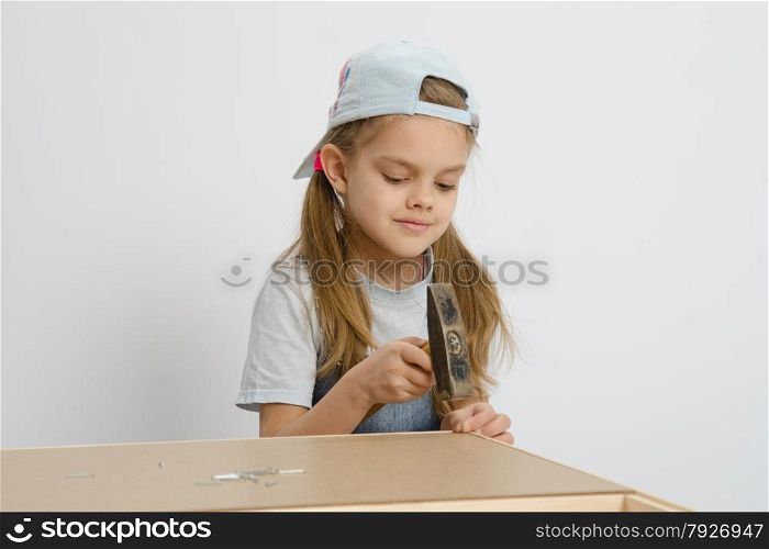 Six year old girl playing and collecting wooden cabinet