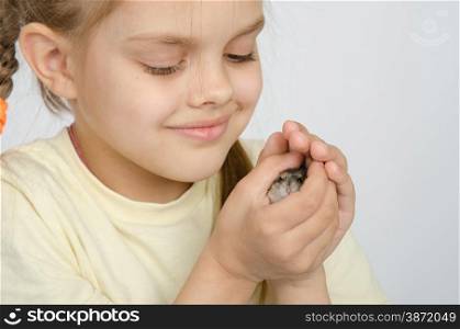 Six year old girl smiling holding pens in the hamster. Girl holding a hamster