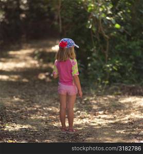 Six year old girl walking through forest in Costa Rica