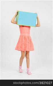 Six year old girl wearing a European-style box on his head, isolated on a light background