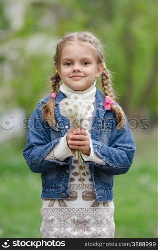 Six year old girl with dandelions. Half-length portrait six-year girl with the bouquet of dandelions in the hands of
