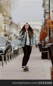 skateboarder girl holding cup coffee while riding skate