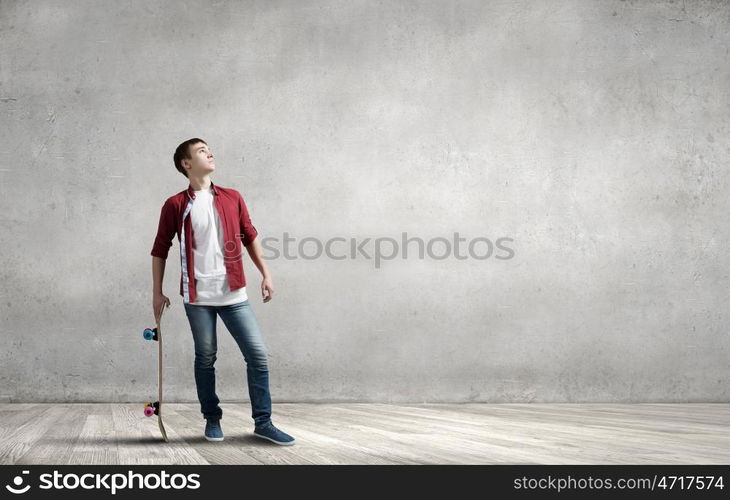 Skateboarder guy. Handsome teenager cool acive boy with skateboard in hand