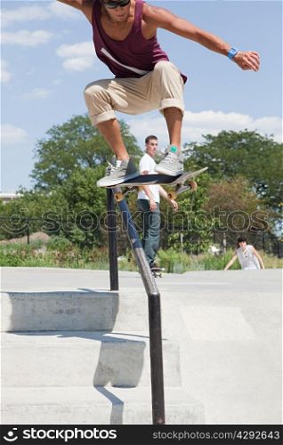 Skateboarder jumping over railing