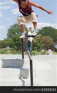 Skateboarder jumping over railing