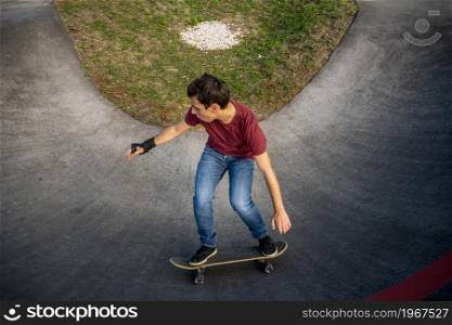 Skateboarder practice on a pump track park on a sunny day.