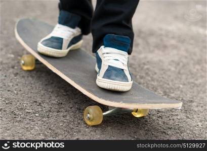 Skateboarder rides on a skateboard feet in sneakers.