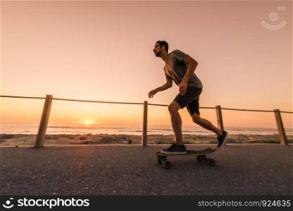 Skater training in the park near the sea in sunset.