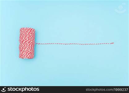 Skein of red and white twine for packing New Year and Christmas gifts, boxes, parcels on blue background. Minimal style Top view Copy space Template for your design.. Skein of red and white twine for packing New Year and Christmas gifts, boxes, parcels on blue background. Minimal style Top view Copy space Template for your design