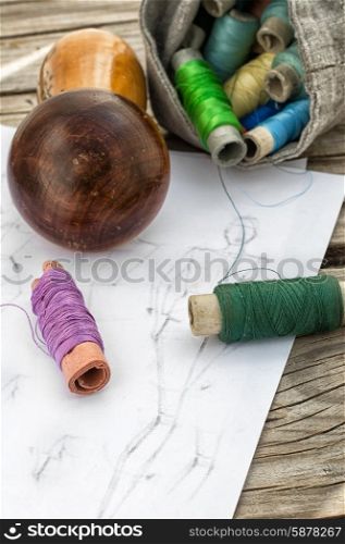 sketch seamstresses. bag sewing thread and a sketch on a wooden table