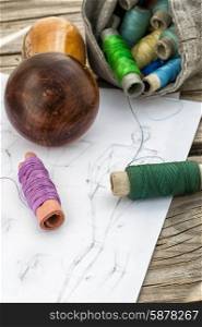 sketch seamstresses. bag sewing thread and a sketch on a wooden table