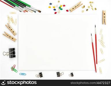 Sketchbook, brushes, paper, office supplies on white background. Artistic flat lay