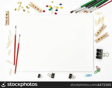 Sketchbook, brushes, paper, office supplies on white background. Flat lay. Creative art concept