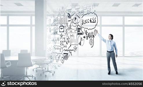Sketching plan of success achieving. Businessman in modern office drawing with marker success plan