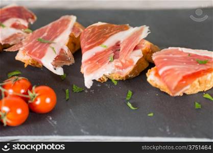 Skewer iberico ham with his bread with tomato